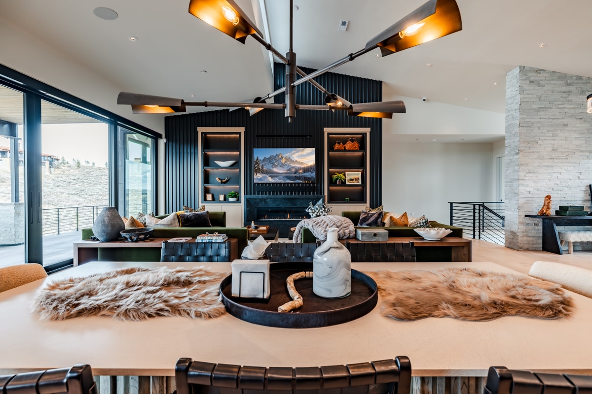 Pinnacle Lot 47 Park City Utah — great room with sculptural chandelier, slatted ebony accent wall, and bi-fold doors to mountain views