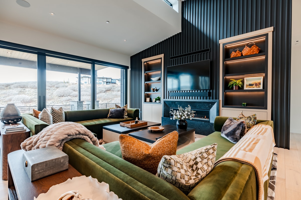 Pinnacle Lot 47 Park City Utah — living room with forest-green velvet sectional, slatted accent wall, and linear gas fireplace