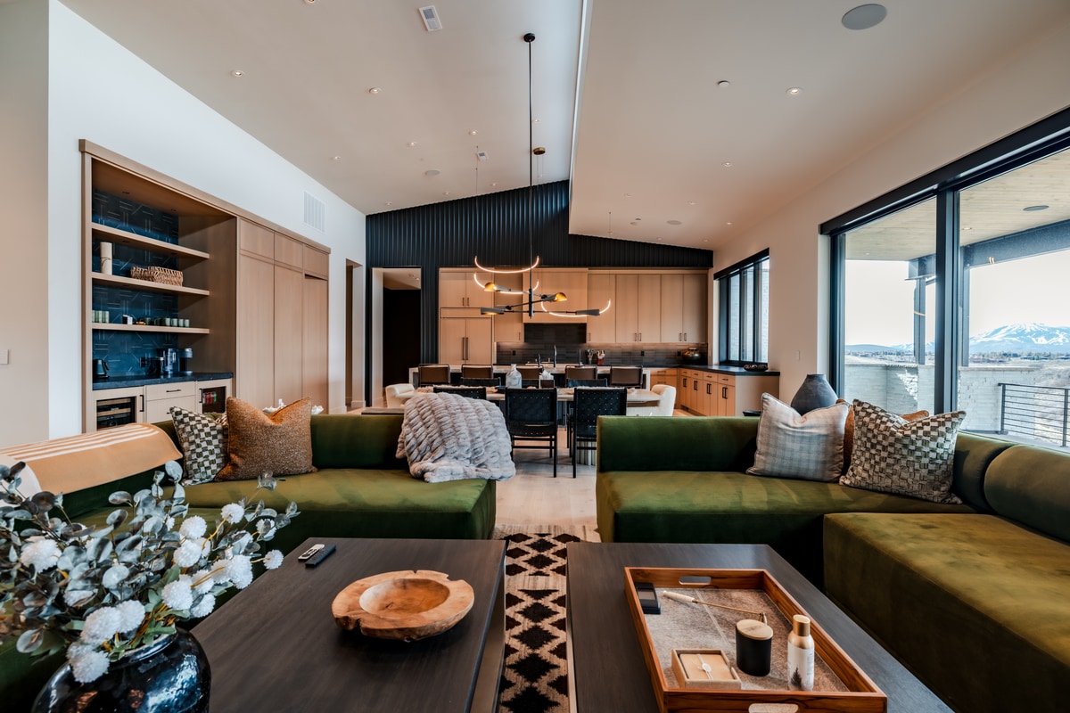 Pinnacle Lot 47 Park City Utah — living area with velvet sectionals, wet bar cabinetry, and snow-covered Wasatch Range views