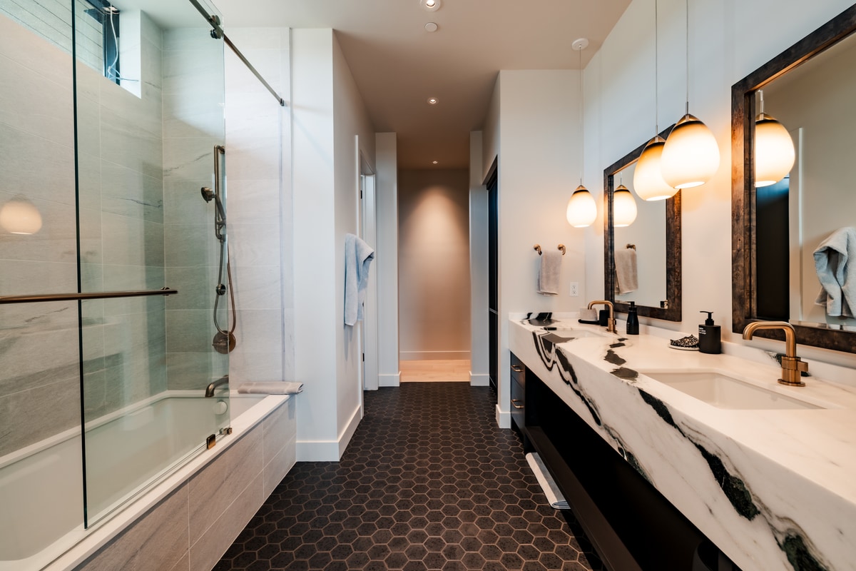 Pinnacle Lot 47 Park City Utah — secondary bath with black-veined marble vanity, hexagonal tile floors, and frameless glass tub