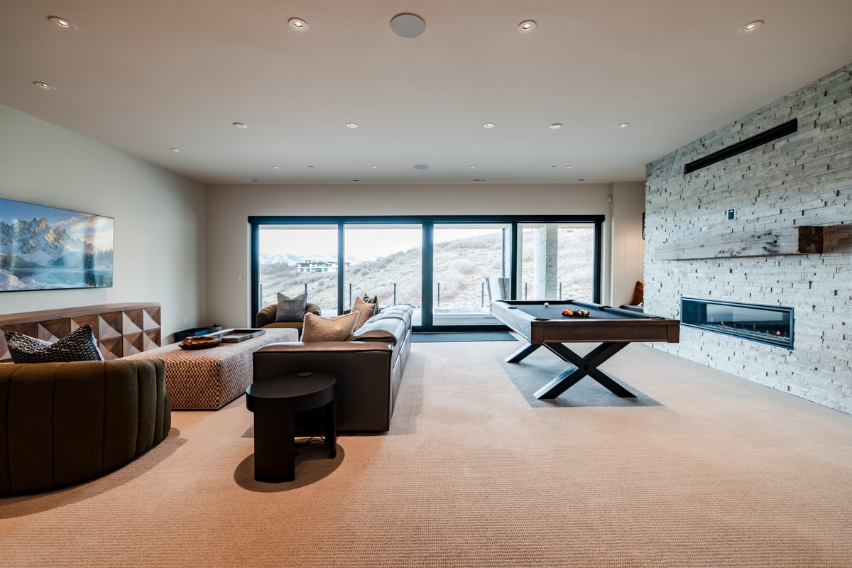 Pinnacle Lot 47 Park City Utah — lower-level recreation room with billiard table, stacked-stone fireplace, and mountain views