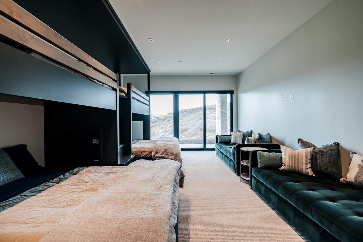 Pinnacle Lot 47 Park City Utah — bunk room suite with custom built-in beds, navy millwork, and patio door to hillside views