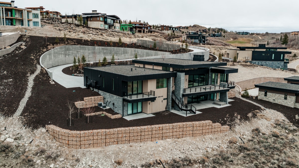 Pinnacle Lot 49 Park City Utah — wide aerial showing full site footprint, retaining walls, and multi-level deck structure