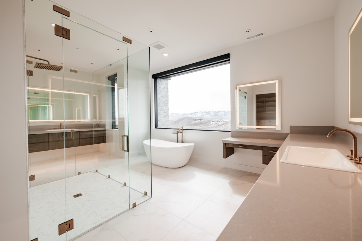 Pinnacle Lot 49 Park City Utah — primary spa bath with frameless glass shower, freestanding soaking tub, and mountain-view window