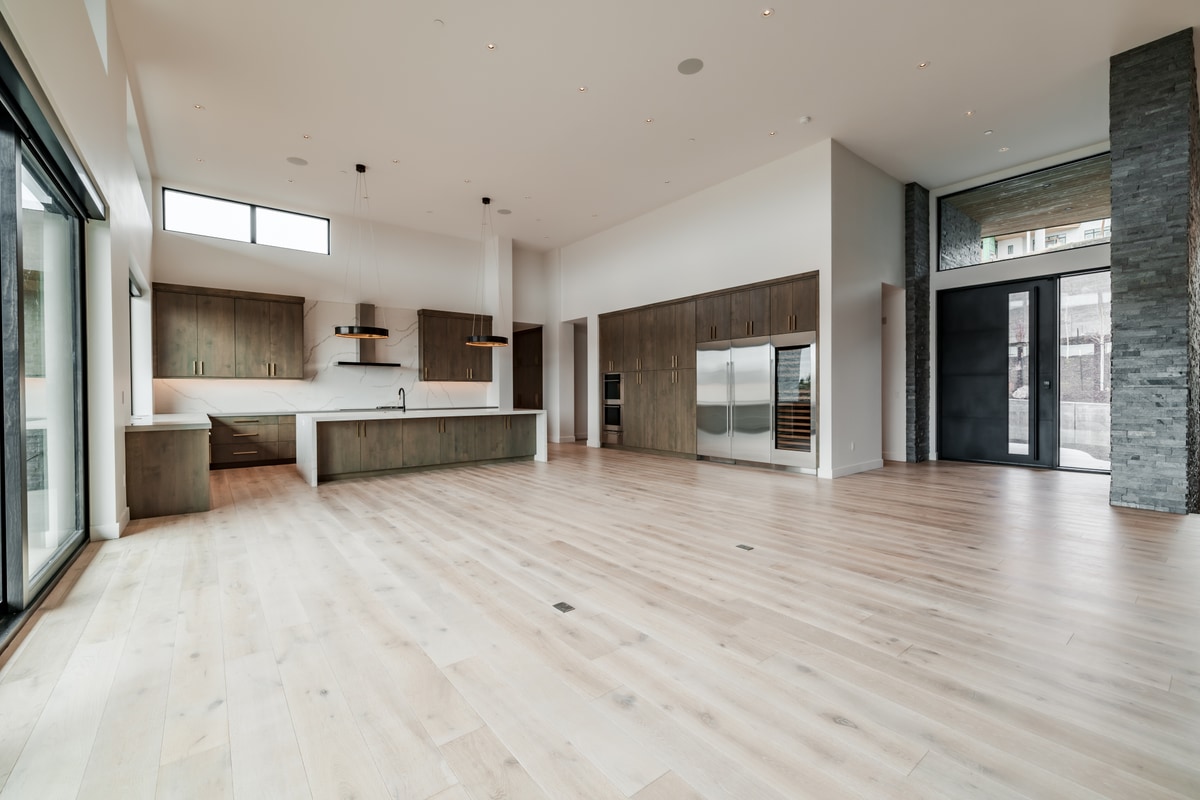 Pinnacle Lot 49 Park City Utah — open great room and kitchen with stainless refrigerator, wine storage, and two-story volume