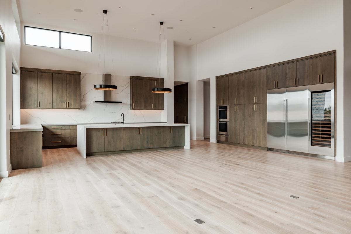 Pinnacle Lot 49 Park City Utah — chef's kitchen with full-height cabinetry, wine column, and pendant lighting over quartz island
