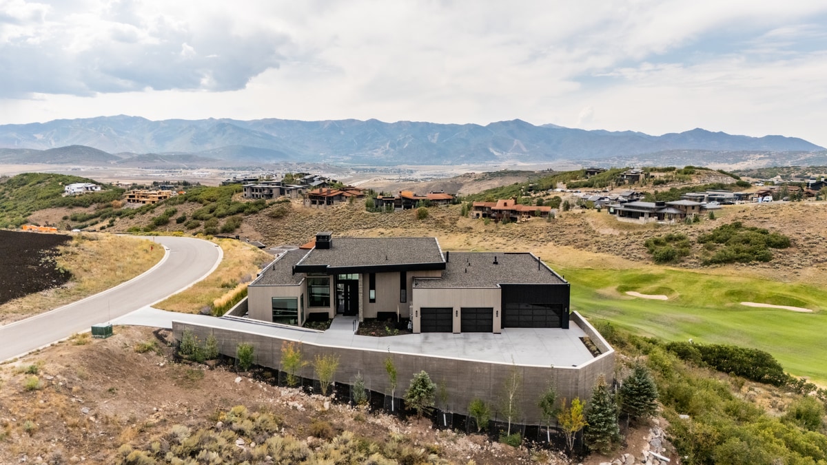 Promontory Lot 52 Park City Utah — aerial view of custom home with three-car garage overlooking golf course and Wasatch Range