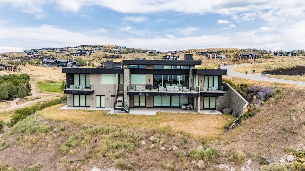 Promontory Lot 52 Park City Utah — rear elevation with floor-to-ceiling glazing, cantilevered upper deck, and tiered terraces