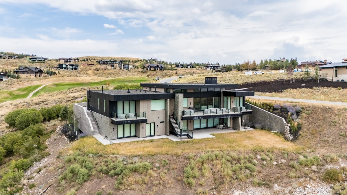 Promontory Lot 52 Park City Utah — exterior rear facade with dark metal cladding, wraparound deck, and panoramic hillside views