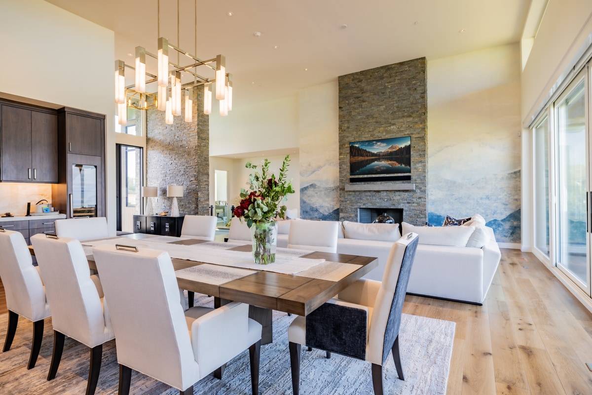 Promontory Lot 52 Park City Utah — dining and great room with stacked-stone fireplace, mountain mural, and wide-plank hardwood floors