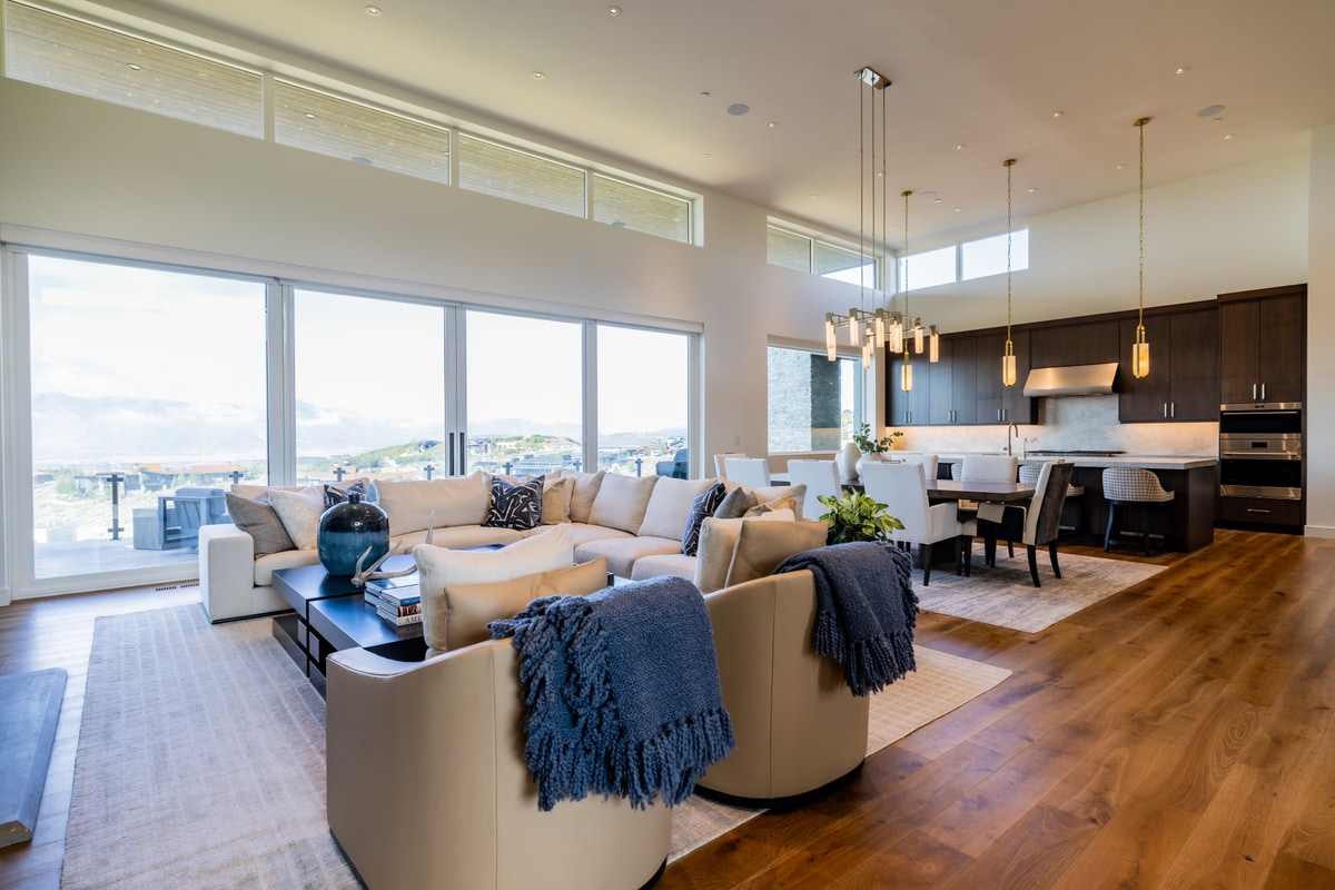 Promontory Lot 52 Park City Utah — open-concept living area with sectional seating, view windows, and gourmet kitchen sightlines