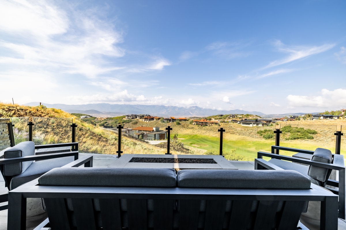Promontory Lot 52 Park City Utah — upper deck with linear fire pit table, outdoor seating, and Wasatch Range panorama