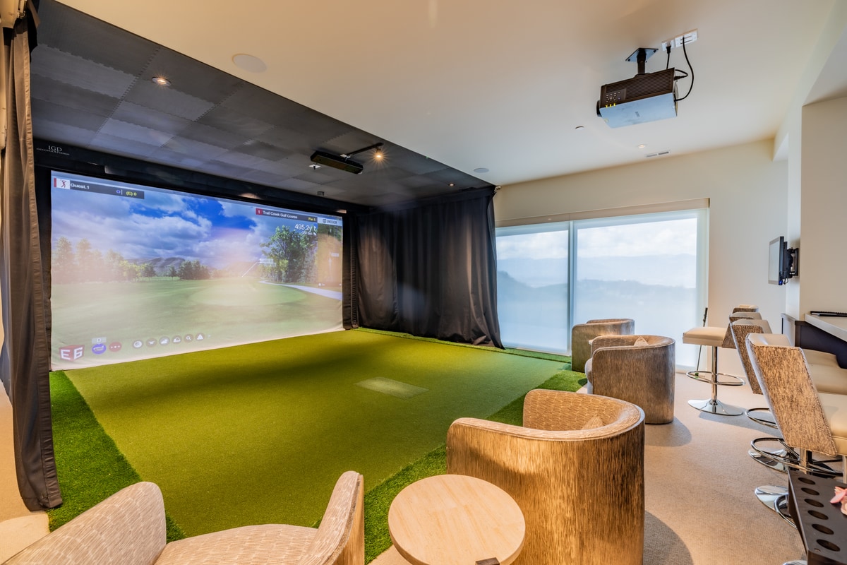Promontory Lot 52 Park City Utah — indoor golf simulator with full-turf hitting area, projection screen, and lounge seating