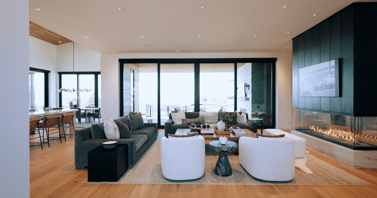 Promontory Model Home Park City Utah — great room with linear fireplace, black feature wall, white oak floors, and floor-to-ceiling mountain views