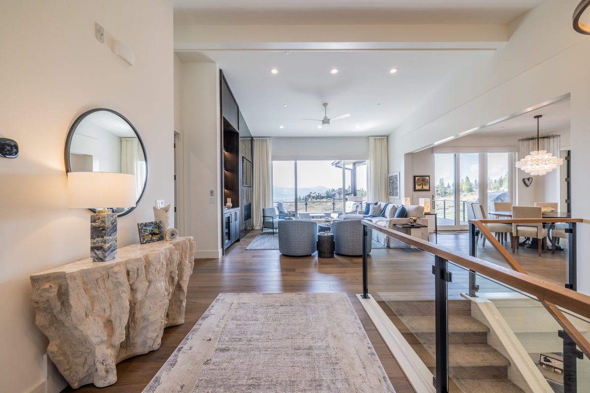 Ranch Gardens Park City Utah — entry foyer with live-edge stone console table, wood-and-glass stair railing, and terrace views