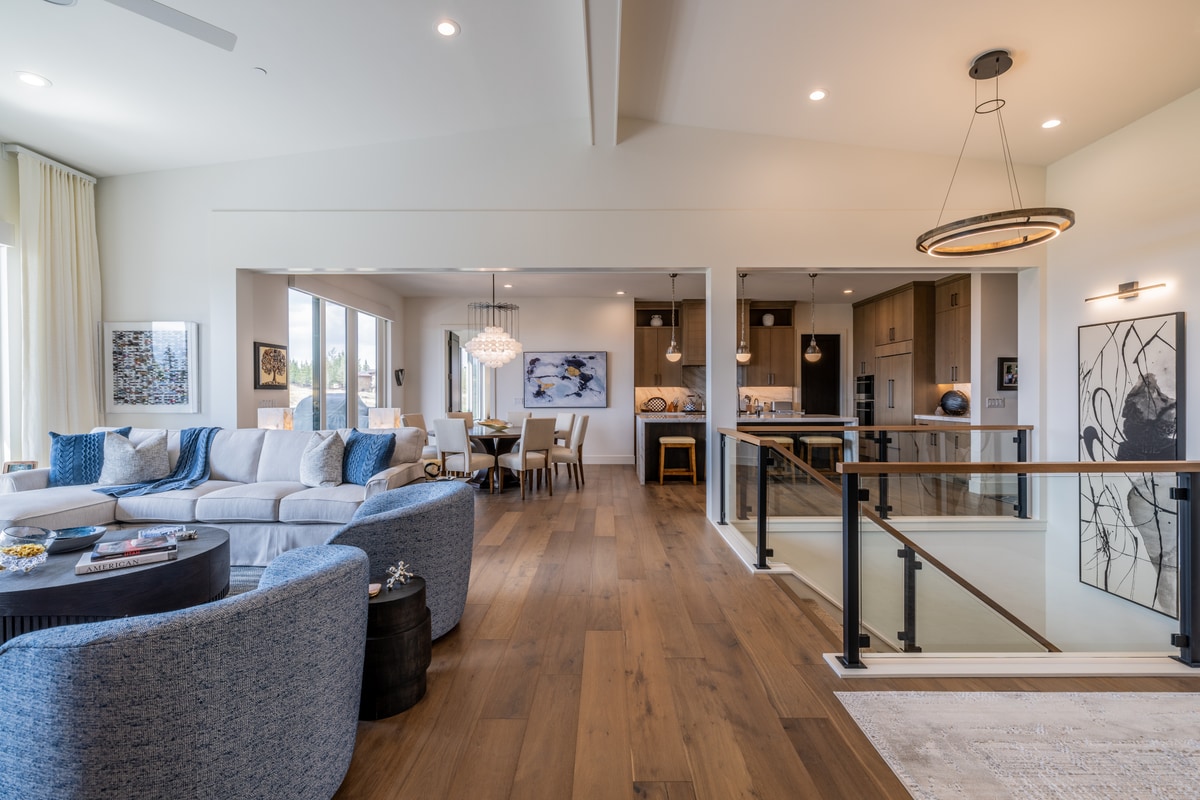 Ranch Gardens Park City Utah — open-plan living and kitchen with oak flooring, glass-railed staircase, and ring chandelier