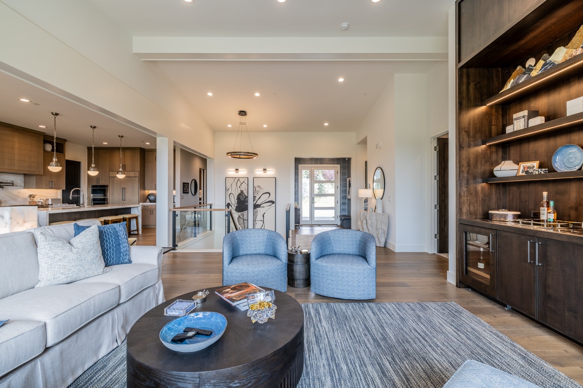 Ranch Gardens Park City Utah — open living space with dark walnut bar cabinet and glass-paneled staircase landing