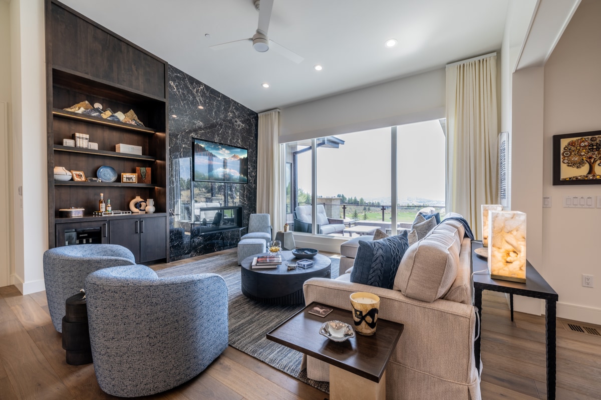 Ranch Gardens Park City Utah — media room with full-height dark marble feature wall, walnut shelving, and sliding glass doors