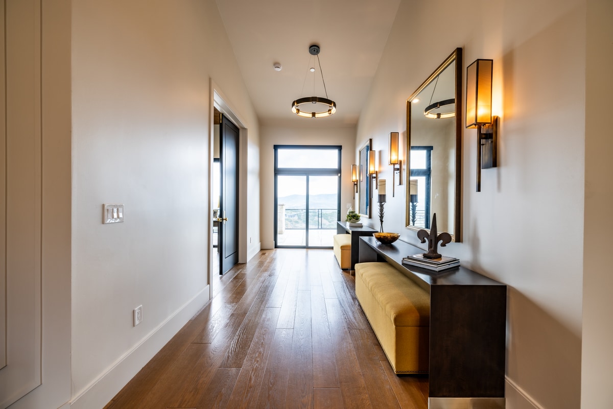 Summit Estates Park City Utah — formal entry hallway with wide-plank hardwood flooring, wall sconces, and view to outdoor balcony