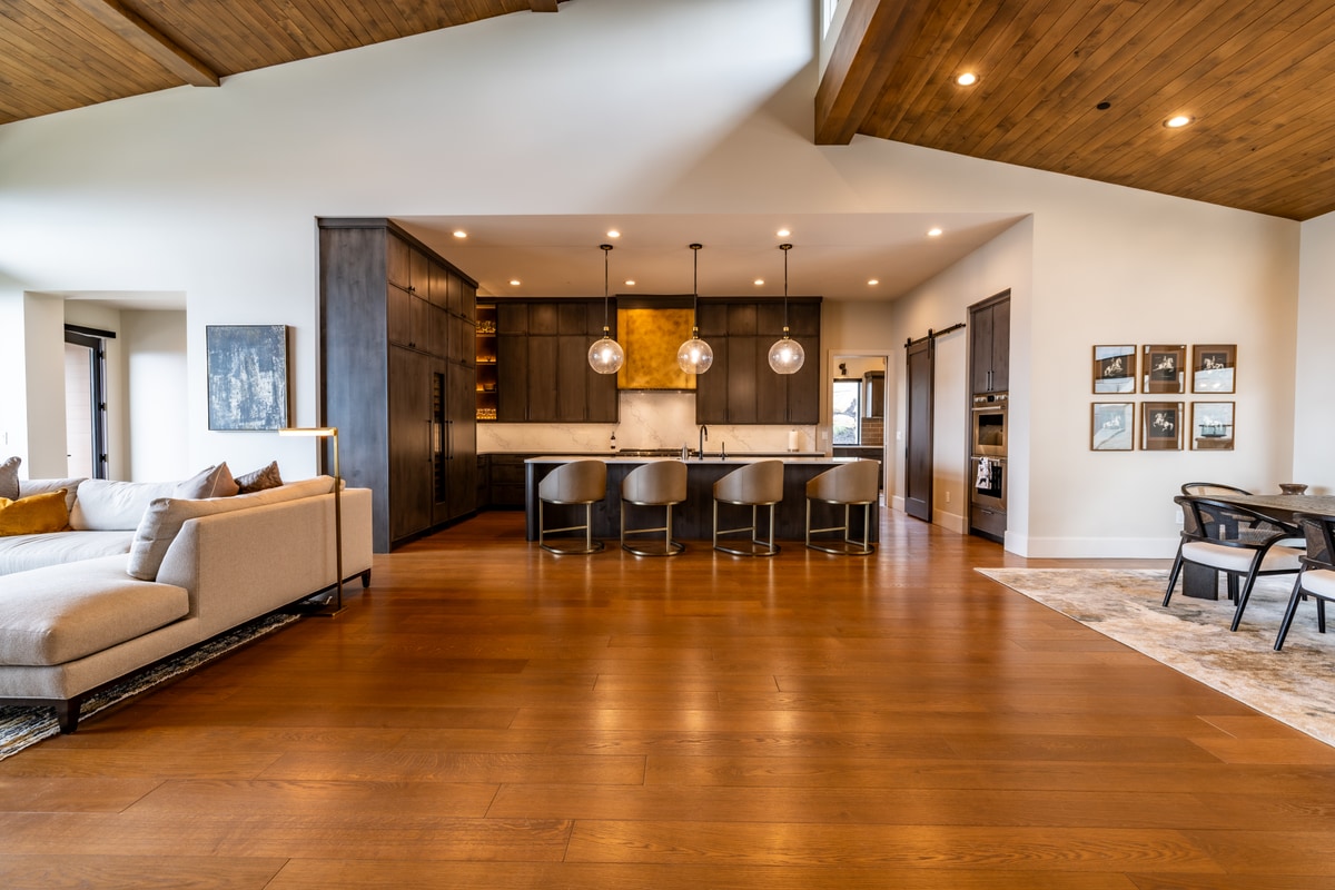 Summit Estates Park City Utah — open-concept great room with vaulted beam ceiling, wide-plank hardwood floors, and kitchen island