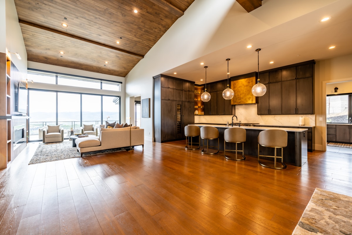 Summit Estates Park City Utah — great room to kitchen view with wood plank vaulted ceiling, oversized island, and valley views