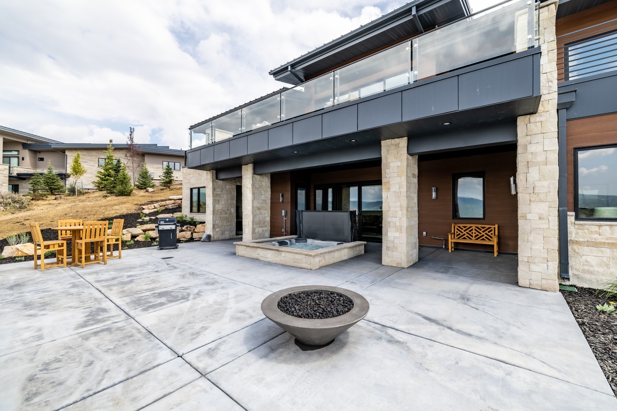 Summit Estates Park City Utah — rear patio terrace with concrete fire bowl, outdoor seating, and mountain backdrop